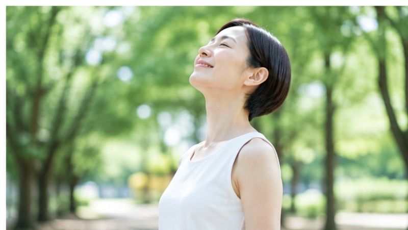 首の不調がやわらぎ、すっきり深呼吸する女性